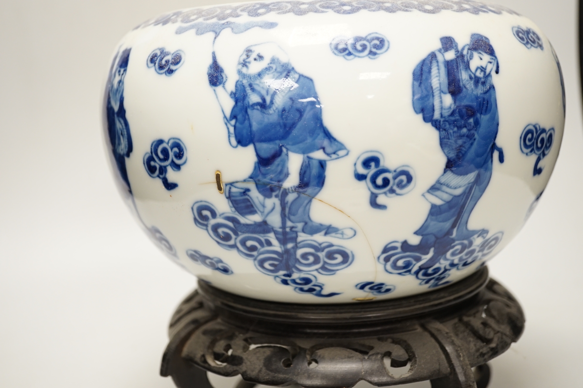 A 19th century Chinese blue and white ‘eight immortals’ alms bowl, apocryphal Qianlong seal mark, 25cm diameter (a.f.), wood stand